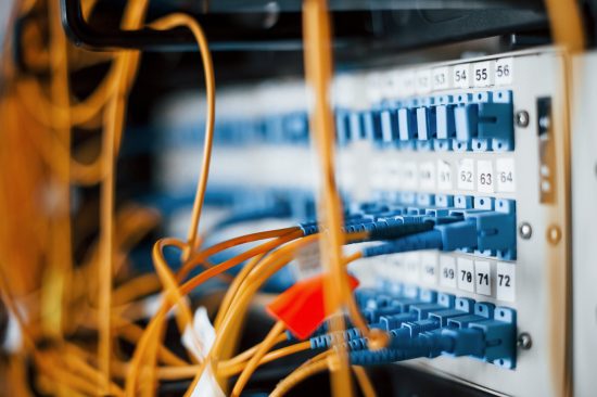 Network equipment with blue patch panels and connected cables, illustrating IT infrastructure for dental clinics and network support services.